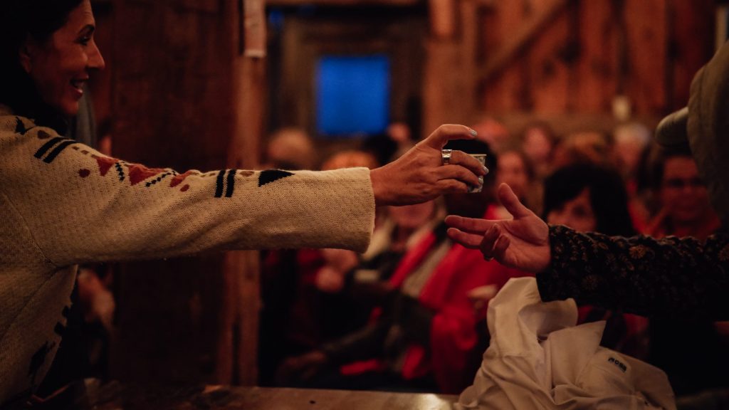 A cup of tea being handed from one person to another.