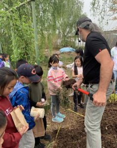 Thomas allowing children to feel the heat produced in a compost pile